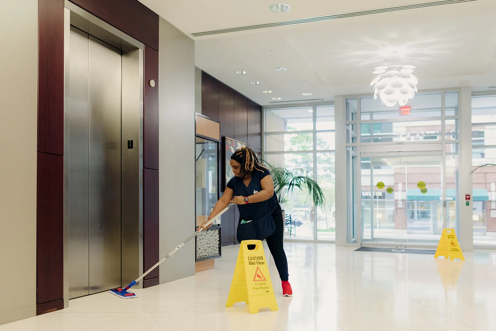 Day porter cleaning a commercial lobby during business hours in Austin