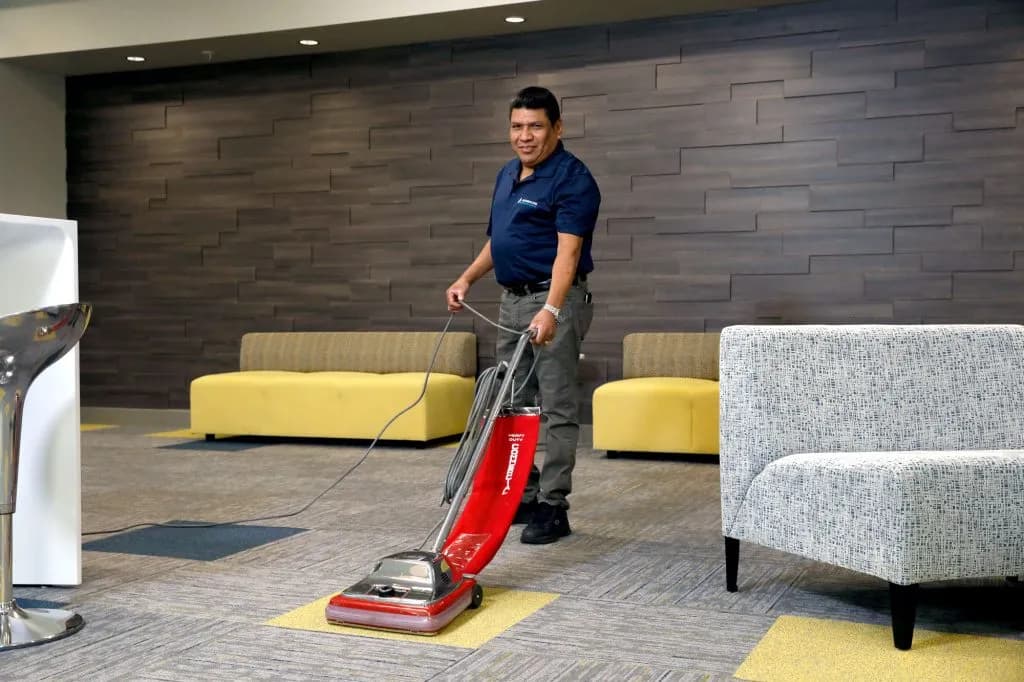 Commercial janitor vacuuming a professional office lobby in Austin