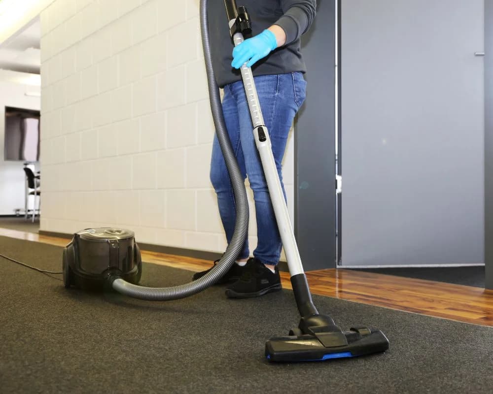 Commercial janitor vacuuming a professional office lobby in Austin